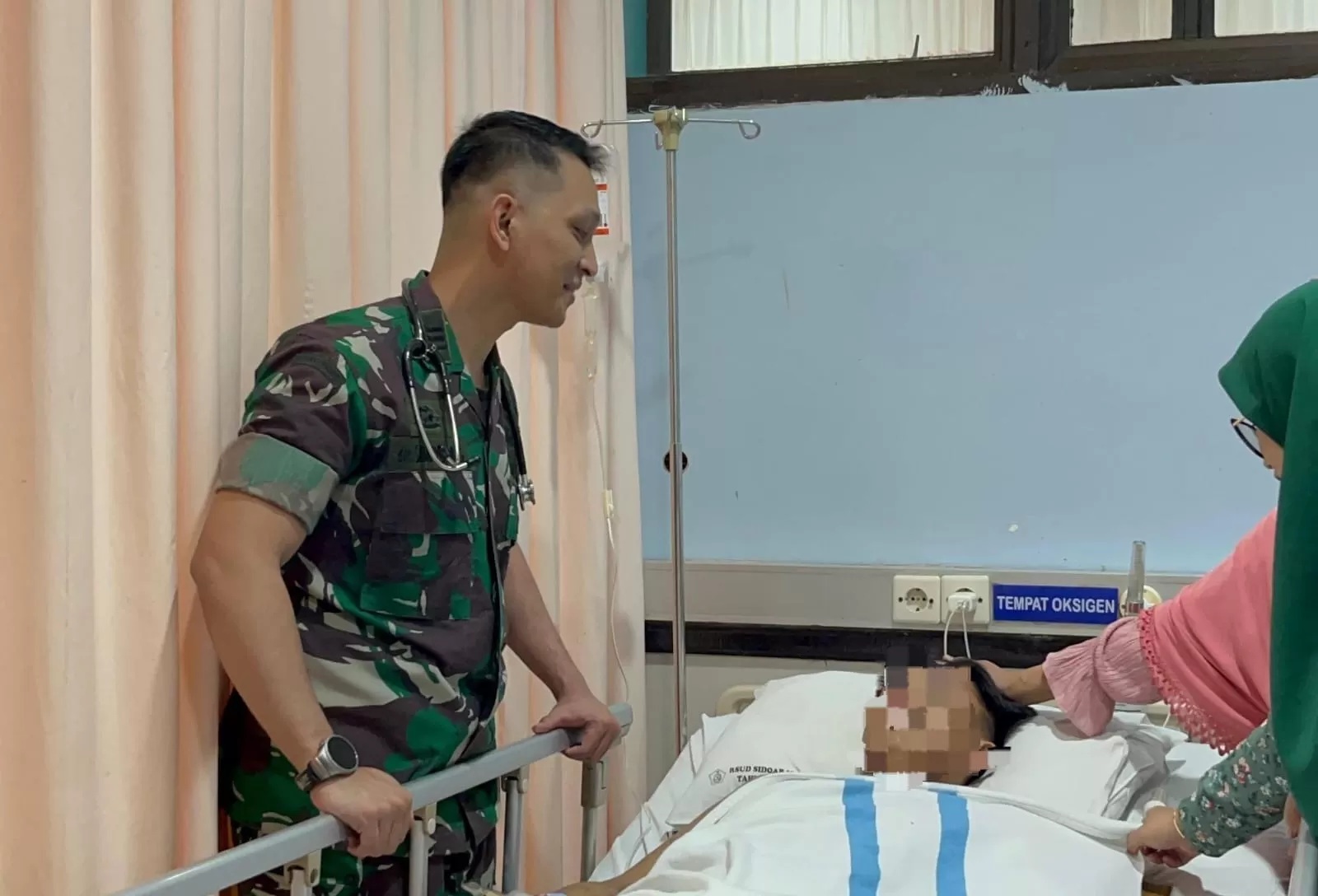 PILIHAN SULIT: Dokter TNI, dr Aaron Franklyn Soaduon Simatupang saat menjenguk salah satu korban di RSUD RT Notopuro.