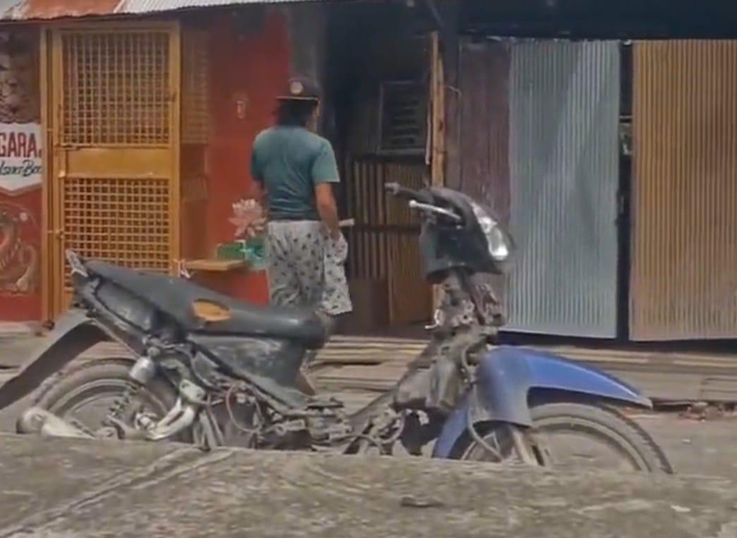 Pria yang membawa anak orangutan menggunakan sepeda motor singgah ke salah satu kios di Jalan Tjilk Riwut Sampit. (Wahid Kelep untuk Radar Sampit)