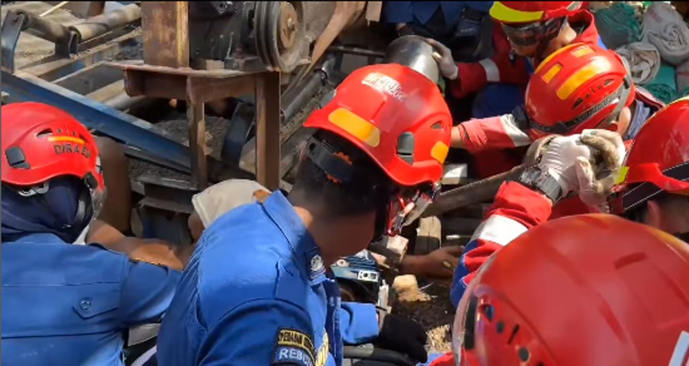 Petugas Disdamkarmat Kotim saat berupaya menyelamatkan seorang karyawan yang tangannya terjepit mesin conveyor di Jalan Mohammad Hatta Lingkar Selatan, Minggu (12/10/2025).