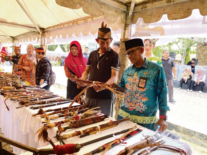 MENINJAU: Pj Sekda Kotim Masri saat melihat pameran Mandau di Museum Kayu Sampit, baru-baru tadi. FOTO: DISBUDPAR KOTIM/RADAR SAMPIT