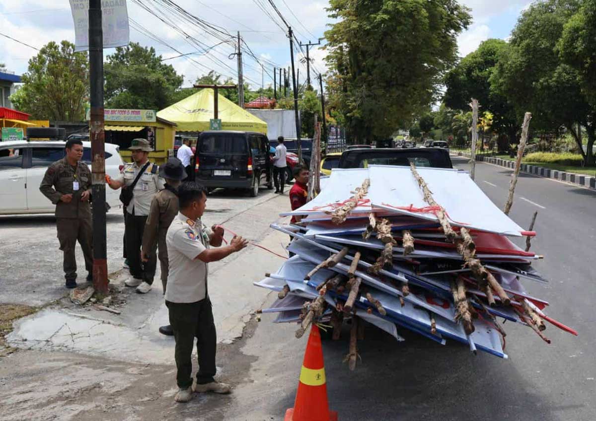 PENERTIBAN: Satpol PP Kota Palangka Raya saat penertiban puluhan baliho dan reklame tanpa izin di ruas Jalan RTA Milono dan Adonis Samad, Rabu (15/10/2025).