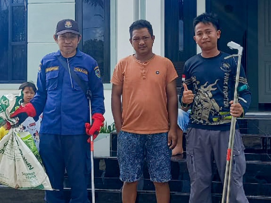 Petugas Damkar Sektor Hanau, Kabupaten Seruyan ketika mengevakuasi seekor ular king kobra dari sebuah rumah warga di Hanau, Minggu (19/10)