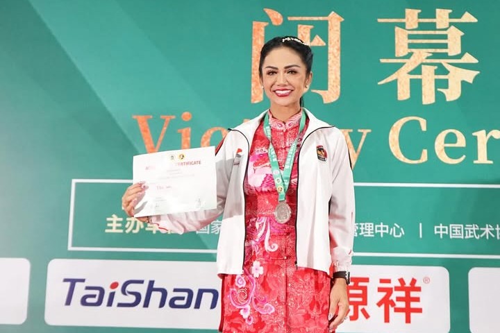 Kris Dayanti saat meraih sertifikat dan medali emas kejuaraan Wushu Internasional  2025 di Tiongkok