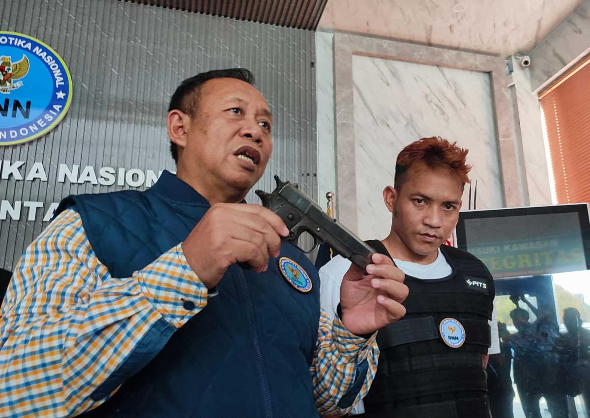 GADUNGAN: Plt Kepala BNN Provinsi Kalteng Kombes Pol Ruslan Abdul Rasyid memperlihatkan barang bukti senpi yang digunakan Maman saat menjadi perwira gadungan BNNP Kalteng.