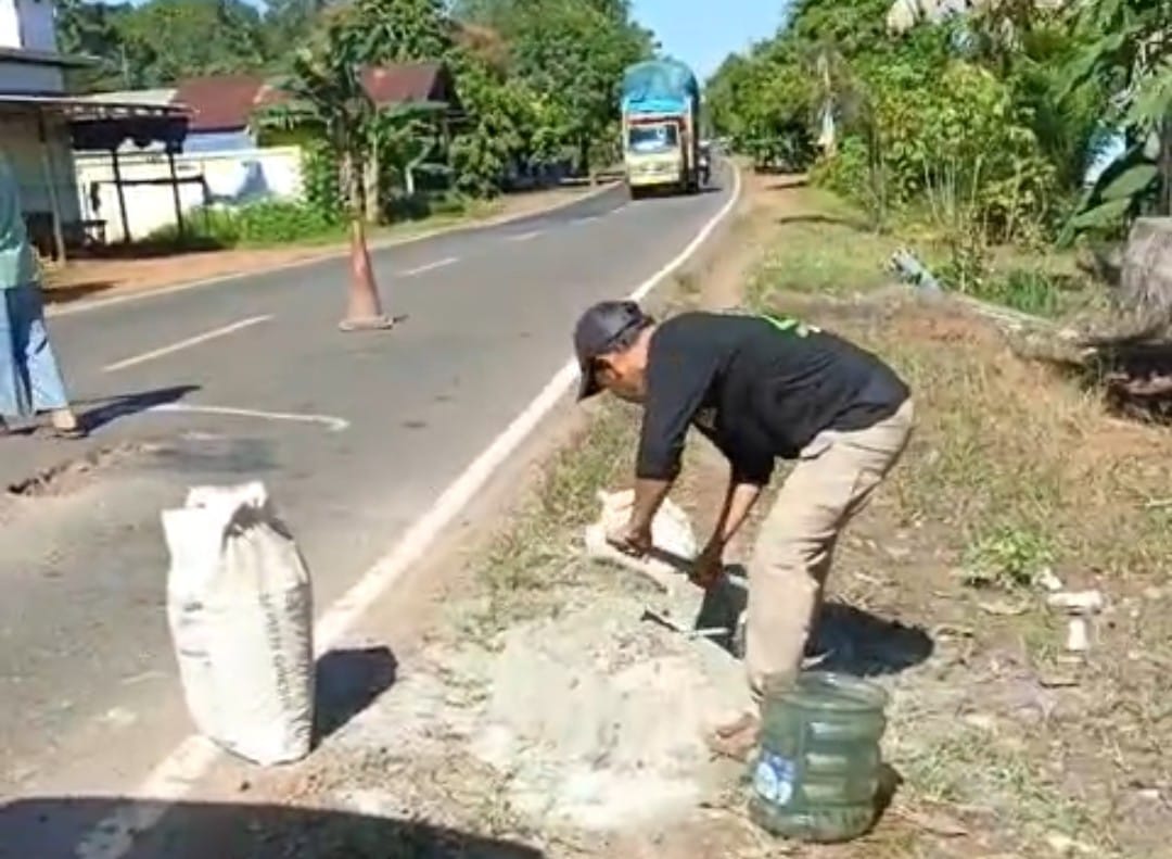 Warga Jemaras menambal jalan rusak di Jalan Tjilik Riwut Kilometer 38 secara swadaya dengan menggunakan ambulans untuk mengangkut materialnya.