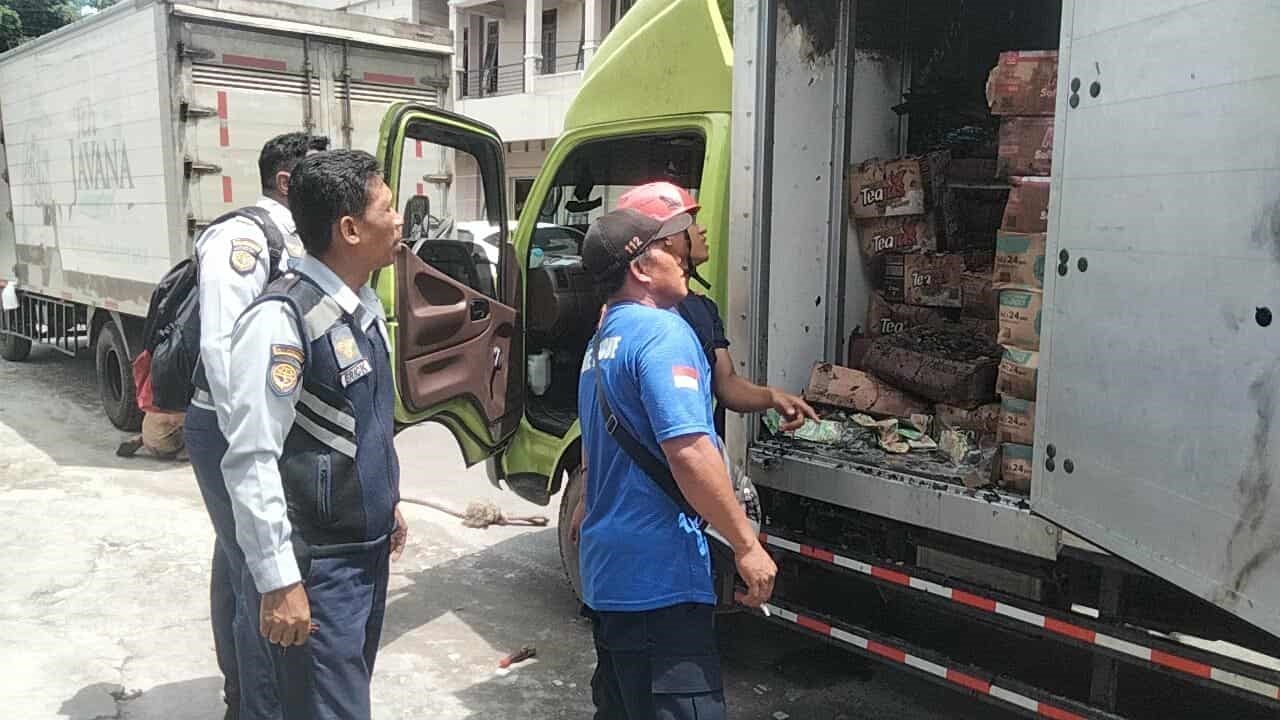 Sejumlah petugas menangani sebuah mobil box yang nyaris terbakar, lantaran sempat mengeluarkan api dari atap dan sempat membakar sejumlah barang, di sekitar Pasar Besar Palangka Raya, Selasa (11/4)