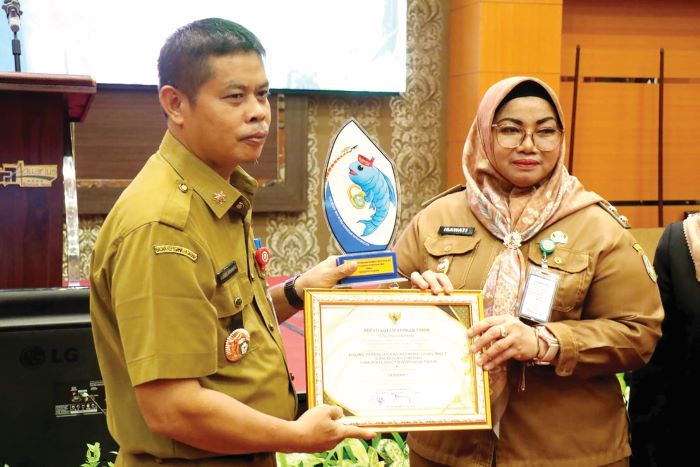 PENGHARGAAN: Wabup Kotim menyerahkan penghargaan kepada Bapperida Kotim sebagai Terbaik I Keterbukaan Informasi Publik Tahun 2025 tingkat kabupaten, Selasa (4/11/2025) pagi. FOTO: YUNI/RADAR SAMPIT