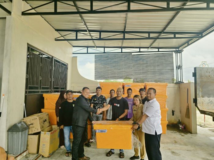 BANTUAN: Wakil Ketua II DPRD Kotim Rudianur (kiri) menyerahkan secara langsung bantuan kotak pendingin ikan kepada nelayan Ujung Pandaran, Teluk Sampit. FOTO: RADO/RADAR SAMPIT
