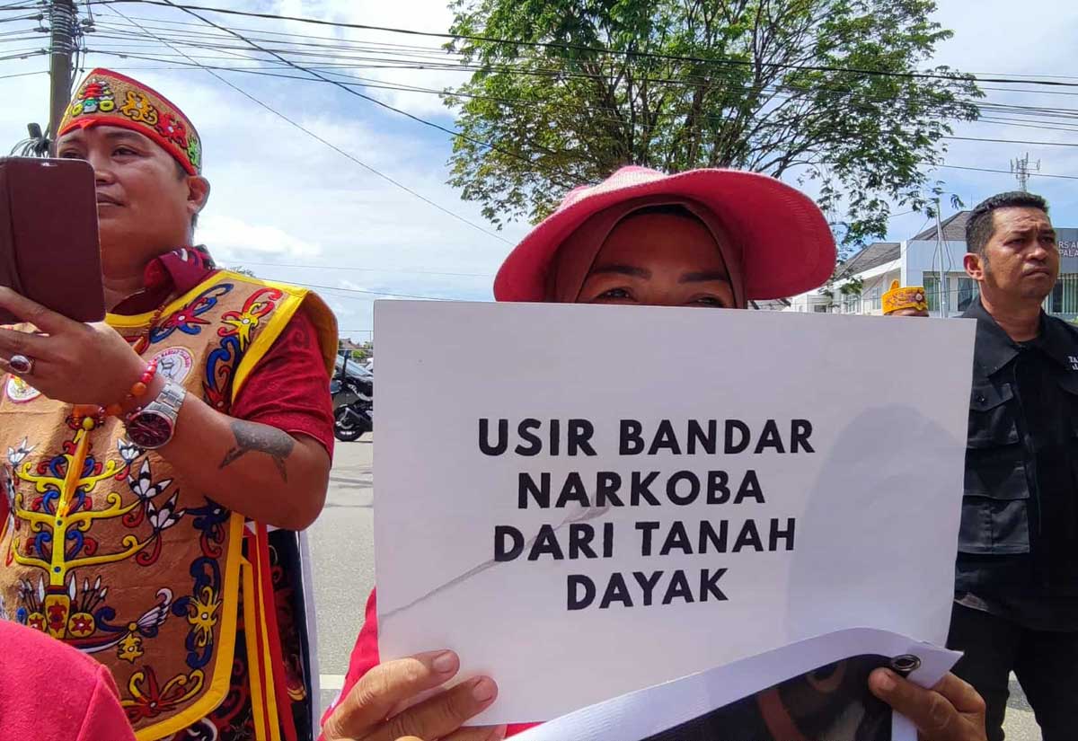 SUARAKAN KEADILAN: Peserta massa Gerakan Dayak Anti Narkoba (GDAN) membawa spanduk berisi pesan terhadap pengedar narkoba saat aksi unjuk rasa di PN Palangka Raya, Jumat (7/11).