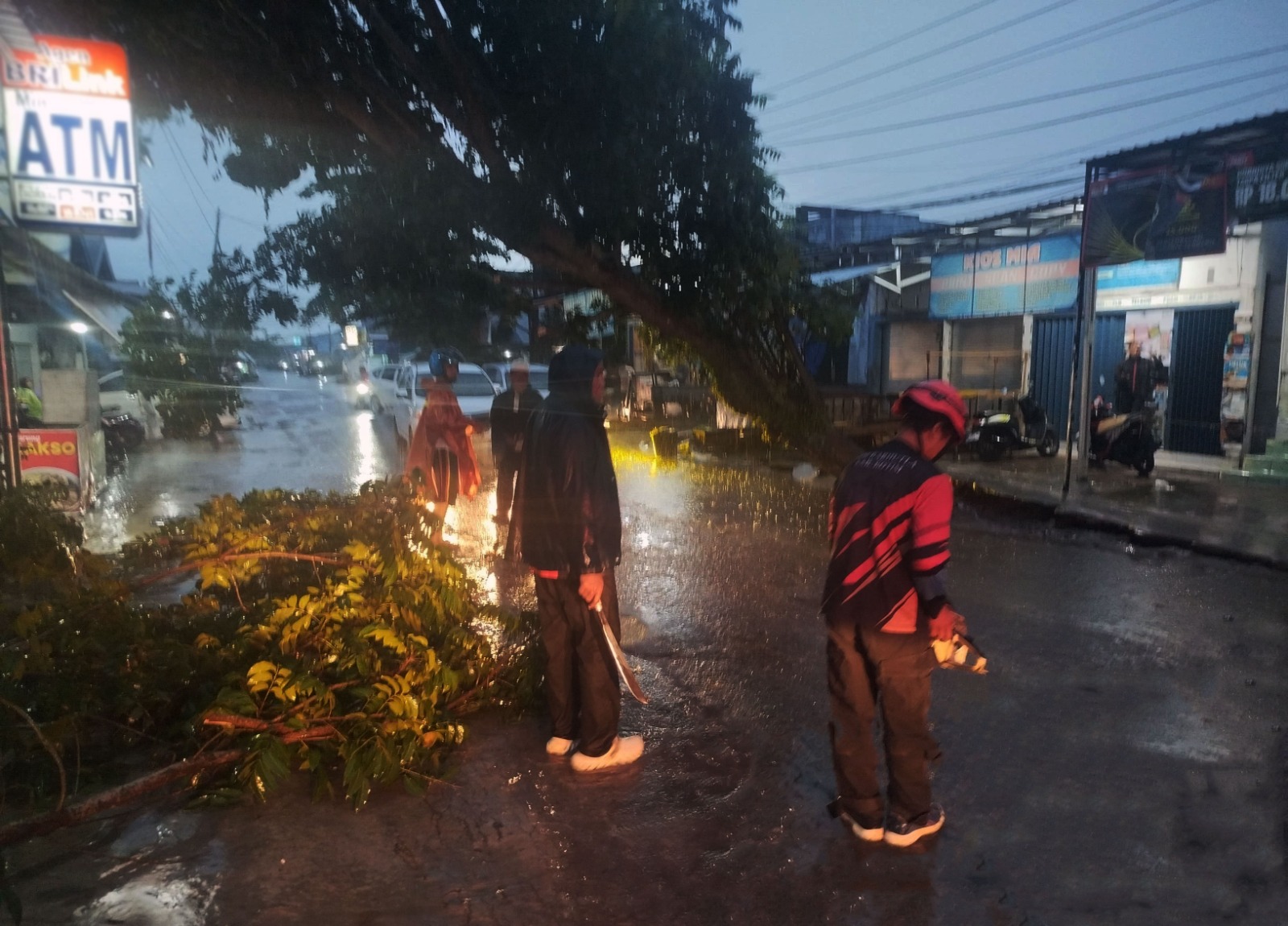 Petugas bersama warga memotong pohon besar yang menghalangi jalan di Jalan DI Panjaitan Sampit,&nbsp;Minggu sore (9/11/2025). (Oes/Radar Sampit)