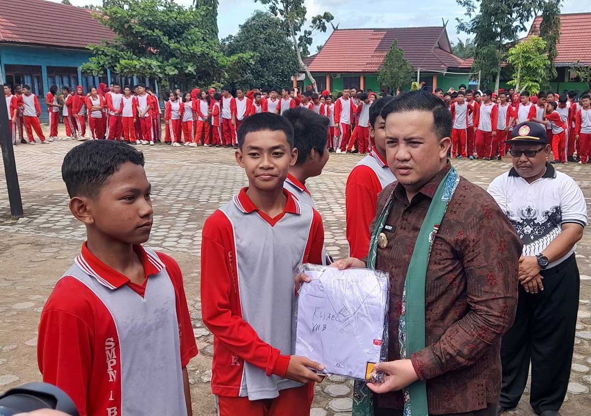 ANTUSIAS: Bupati Lamandau Rizky Aditya Putra menyerahkan seragam gratis untuk siswa SMPN 1.