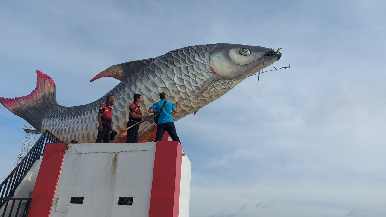 PETUGAS: Petugas gotong royong membersihkan tumbuhan liar di Patung Ikan Jelawat.&nbsp;DISKOPERINDAG KOTIM UNTUK RADAR SAMPIT&nbsp;
