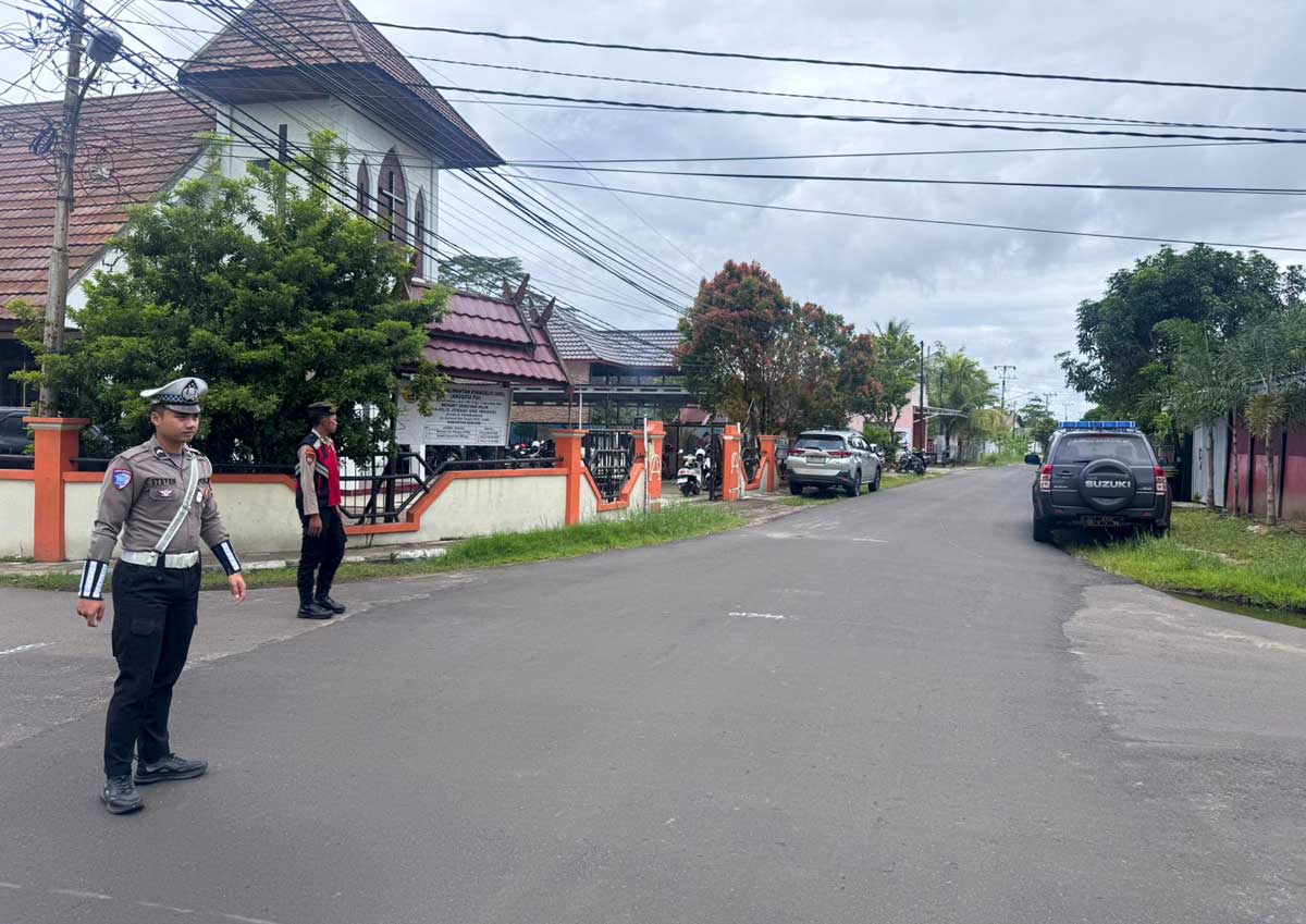 KAWAL IBADAH: Anggota kepolisian melakukan pengamanan di area gereja saat ibadah berlangsung, Minggu (16/11).