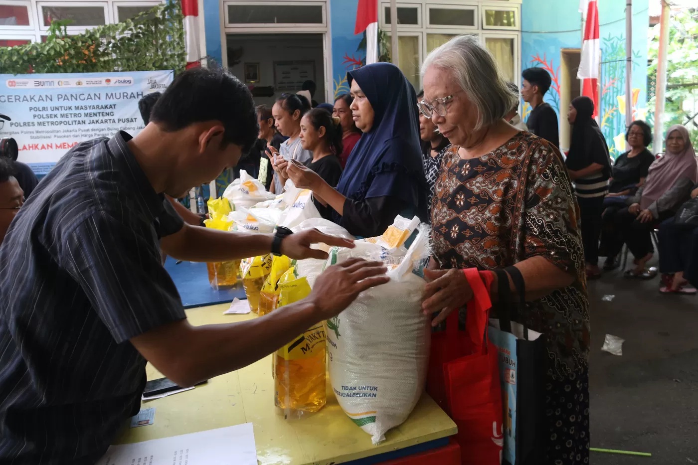Warga saat pengambilan bantuan pangan gratis berupa beras dan minyak goreng di Balai RW 03 Menteng, Jakarta Pusat, Rabu (12/11/2025). (Dery Ridwansah/JawaPos.com)