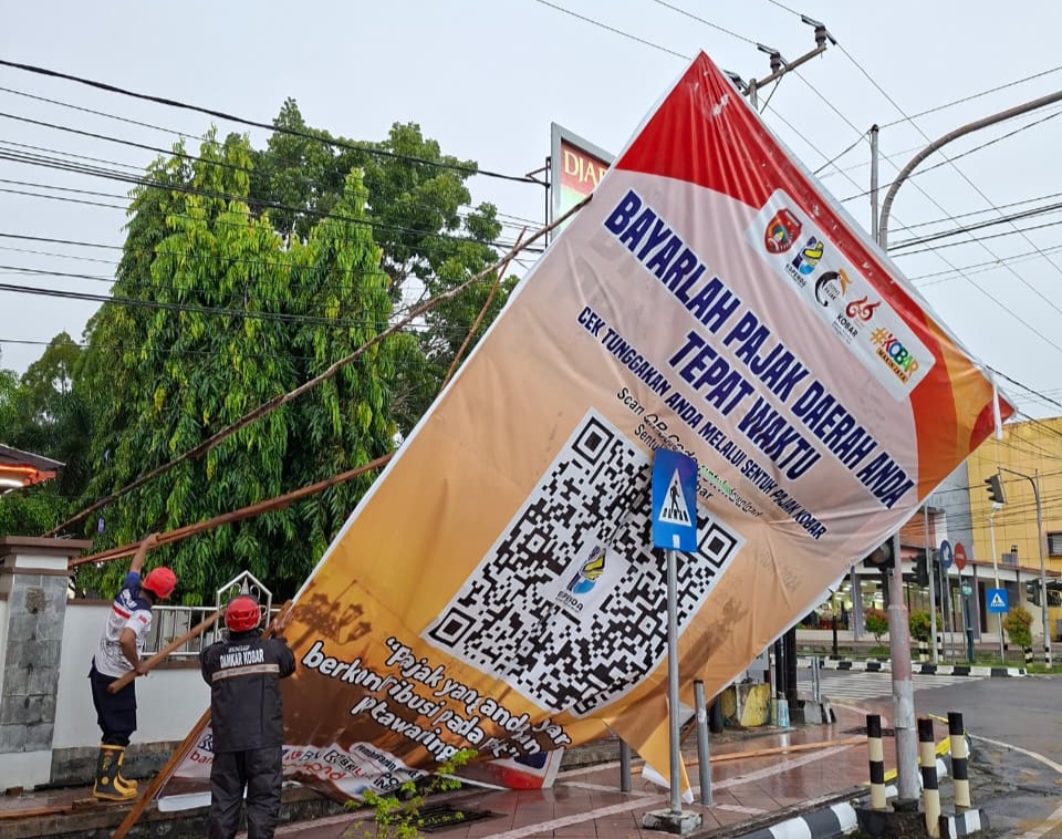 Petugas Damkar Kobar mengevakuasi pembongkaran baleho yang tumbang di simpang Bank Kalteng.