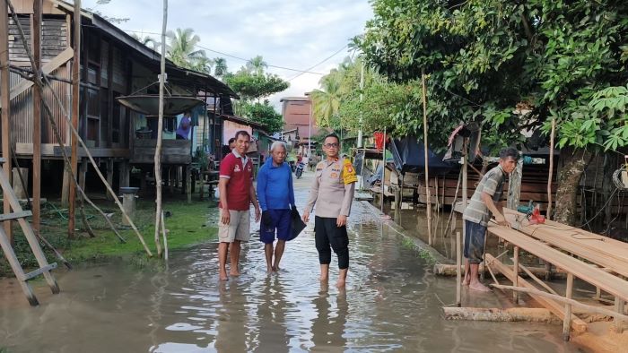 MULAI SURUT : Personel Polsek Rungan ketika memantau kondisi banjir yang telah surut di Desa Jangkit, Kecamatan Rungan Hulu, Gunung Mas, Jumat (21/11/2025). FOTO : HUMAS POLRES GUMAS/RADAR SAMPIT