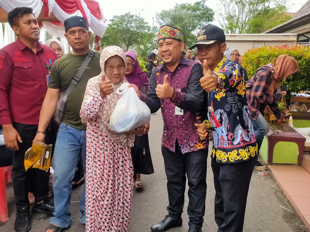 Kepala Perum Bulog Cabang Kotim Muhammad Azwar Fuad (tengah), bersama Camat Baamang Sufiansyah, saat penyerahan bantuan pangan Presiden kepada warga yang membutuhkan, Sabtu (22/11).