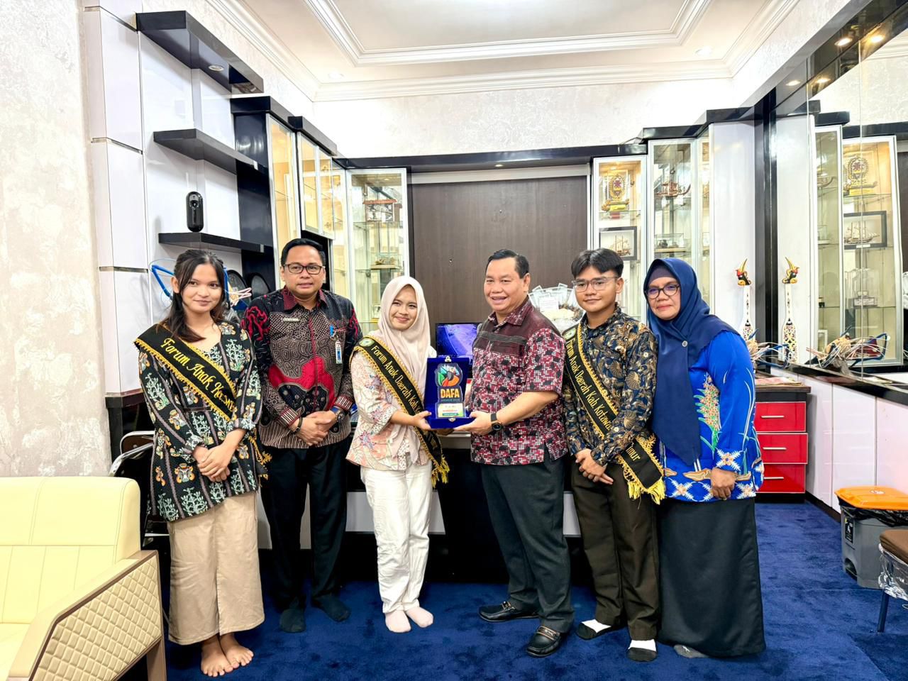 Plt Kepala DP3AP2KB dr. M. Akhya Ridskie, MAP mendampingi FAD Kotim saat menyerahkan penghargaan DAFA Awards 2025 kepada Bupati Kotim Halikinnor di rumah jabatan Bupati, Jumat (21/11).