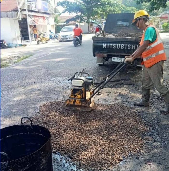 DIPERBAIKI: Dinas PUPR Kobar melakukan penambalan lubang di Jalan Sudirman, Kelurahan Sidorejo, Kecamatan Arsel, belum lama tadi. FOTO: IST/RADAR SAMPIT