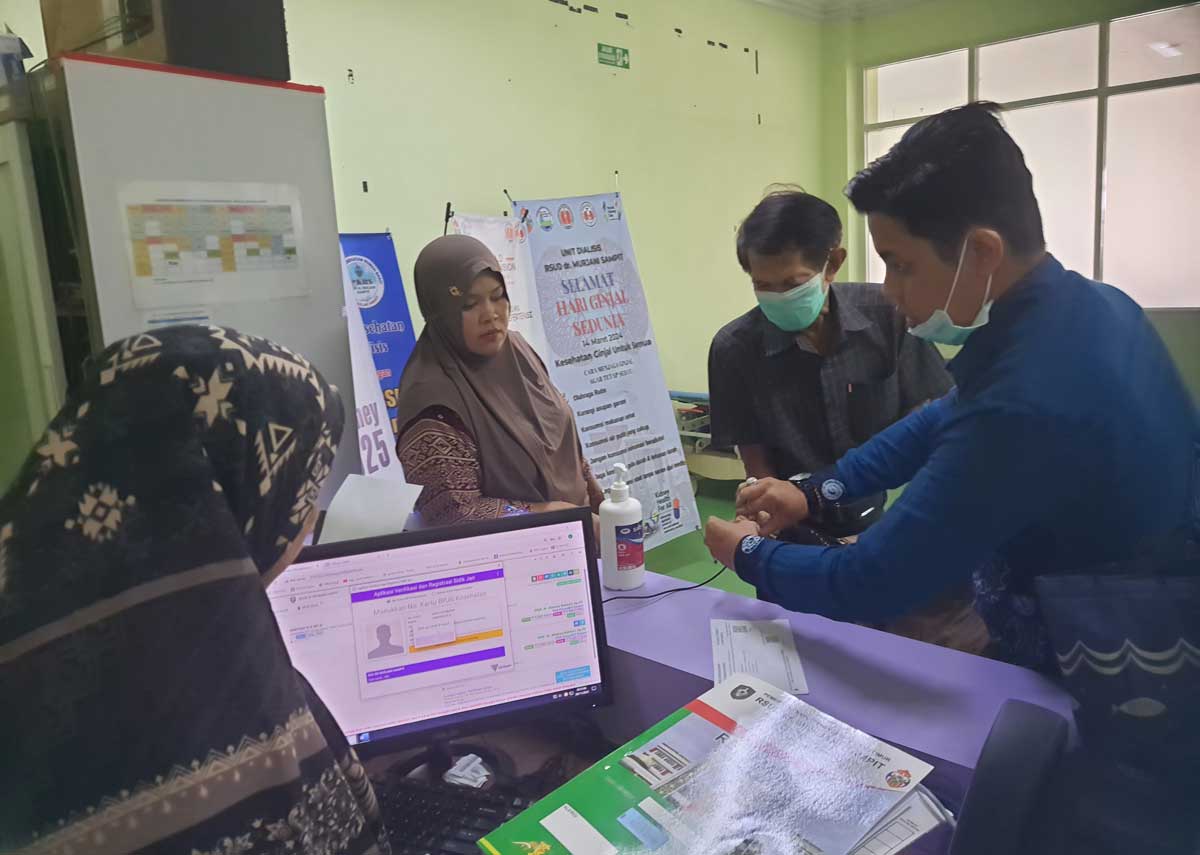 PELAYANAN: Salah seorang pasien yang duduk di kursi roda saat melakukan finger print dibantu petugas medis dan pihak keluarga pasien di Unit Hemodialisis RSUD dr Murjani Sampit, Sabtu (29/11).