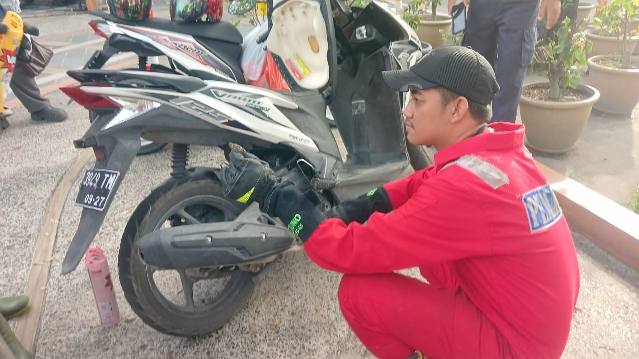 Tim rescue damkar Palangka Raya saat mengevakuasi seekor anak ular piton sepanjang sekitar 90 sentimeter dari dalam spack board motor Honda Vario milik salah satu warga.