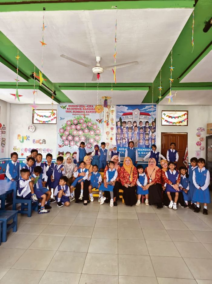 MENGAJAR: Ketua DWP Kotim Pariati Umar Kaderi didampingi pengurus bersama anak-anak TK Pembina. FOTO: YUNI/RADAR SAMPIT