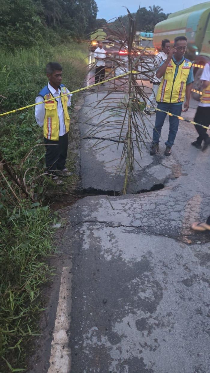 JALAN RUSAK: Petugas beri tanda jalan trans Kalimantan wilayah Sematu Jaya, Lamandau, yang ambles usai tergerus hujan, Kamis (11/12/2025) sore. IST/RADAR SAMPIT