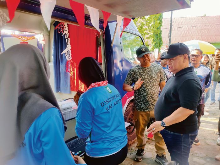 LAYANAN PUBLIK: Bupati Kotim Halikinnor didampingi Kepala Disdukcapil Kotim Wiyono saat mengunjungi mobil layanan keliling Adminduk di kegiatan CFD Taman Kota Sampit, Minggu (7/12/2025) tadi.