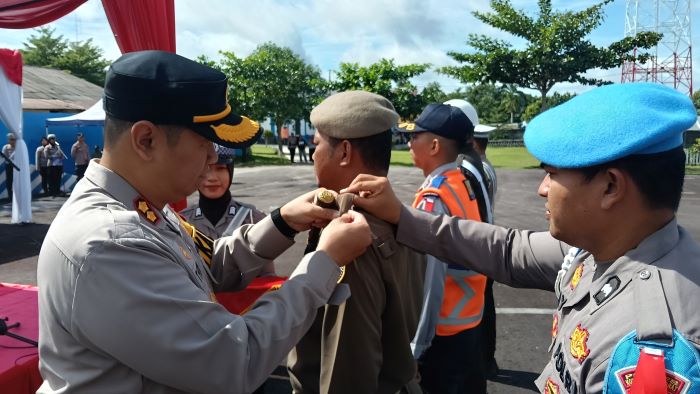 OPERASI LILIN: Kapolres Kobar AKBP Theodorus Priyo Santosa menyematkan tanda kepada personel yang terlibat dalam Operasi Lilin Telabang 2025 di lapangan Satlantas Polresta Kobar, Jumat (19/12/2025) so