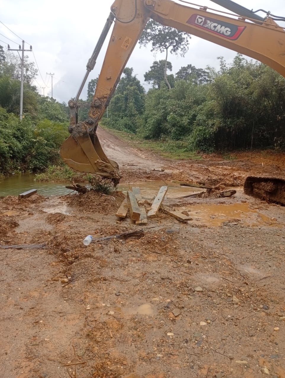 Perbaikan jembatan secara darurat yang menggunakan material kayu dan timbunan tanah, penghubung antar dua desa di Kecamatan Damang Batu, Minggu (21/12).