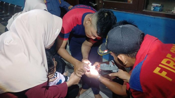 TERJEPIT CINCIN : Tim Rescue Dinas Pemadam Kebakaran (Damkar) Kota Palangka Raya melepas cincin yang sangkut di jari anak 4 tahun, Selasa (23/12/2025) malam. FOTO: DAMKAR/RADAR SAMPIT