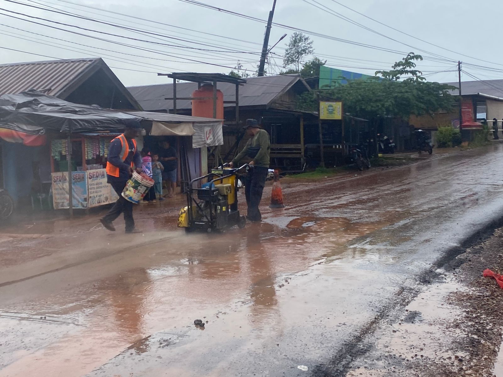 Petugas lapangan saat mulai memperbaiki kerusakan kecil di Jalan Lesa Parenggean, Senin (5/1/2025) yang baru selesai diaspal pada akhir Desember 2025.