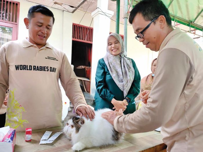 VAKSINASI: Petugas melakukan vaksinasi terhadap hewan peliharaan. FOTO: DOK.YUNI/RADAR SAMPIT