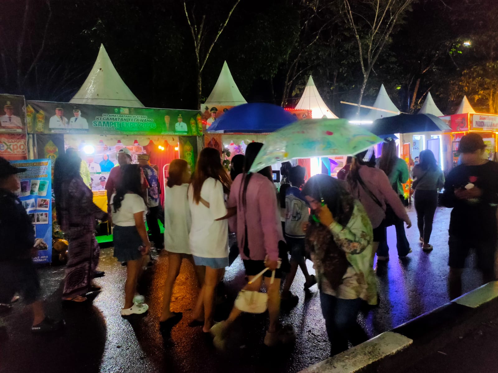 Pengunjung di tengah cauca hujan tetap memadati arena Sampit Expo 2026, menjelang pembukaan, Rabu (1/7) malam.