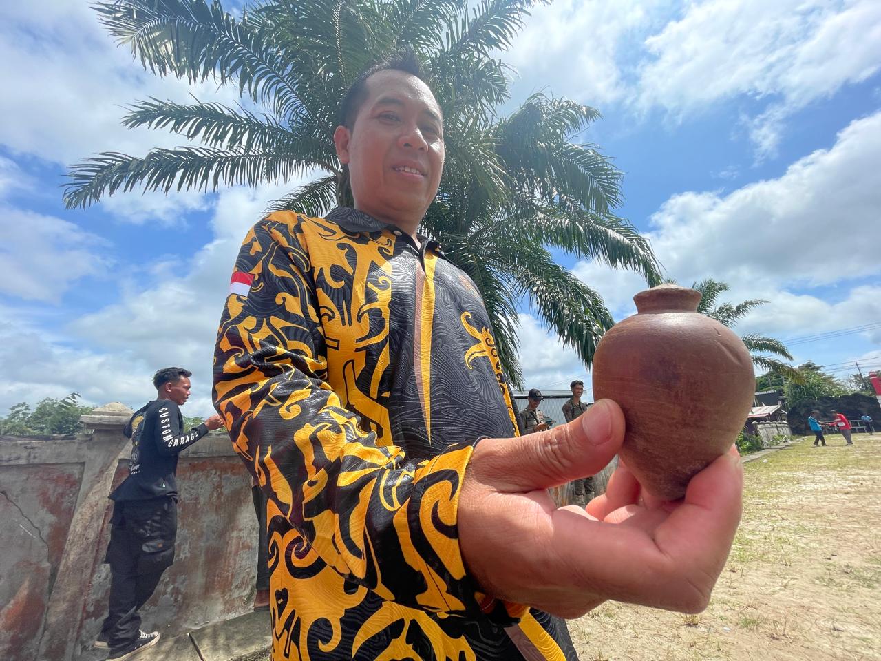 TRADISI: Camat Telaga Antang Joko Aryadi Stewan memamerkan salah satu gasing terbuat dari kayu ulin khas dari Kalimantan. (Oes/Radar Sampit)