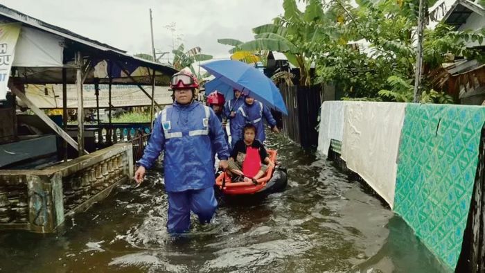 BANTU KORBAN: Petugas DPKP Kabupaten Banjar mengevakuasi lansia sakit yang terjebak banjir di Kelurahan Murung Keraton, Kecamatan Martapura 5 Januari 2026 lalu. (DPKP Banjar untuk Radar Banjarmasin)