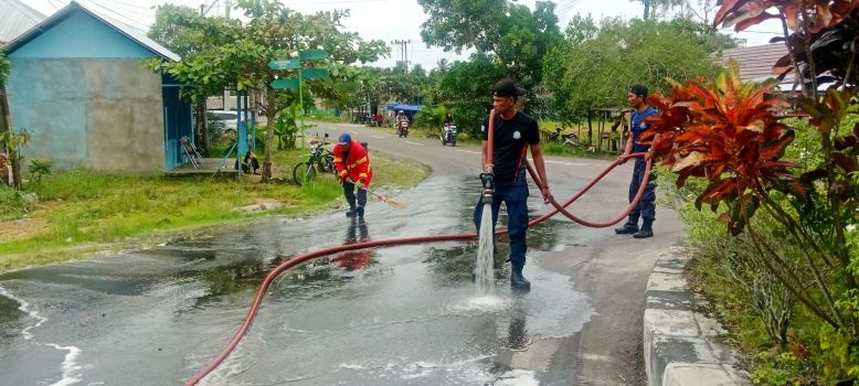 DIBERSIHKAN : Damkar Seruyan membersihkan tumpahan minyak di jalan umum Desa Pematang Panjang, Seruyan Hilir Timur, Kamis (8/1/2026).