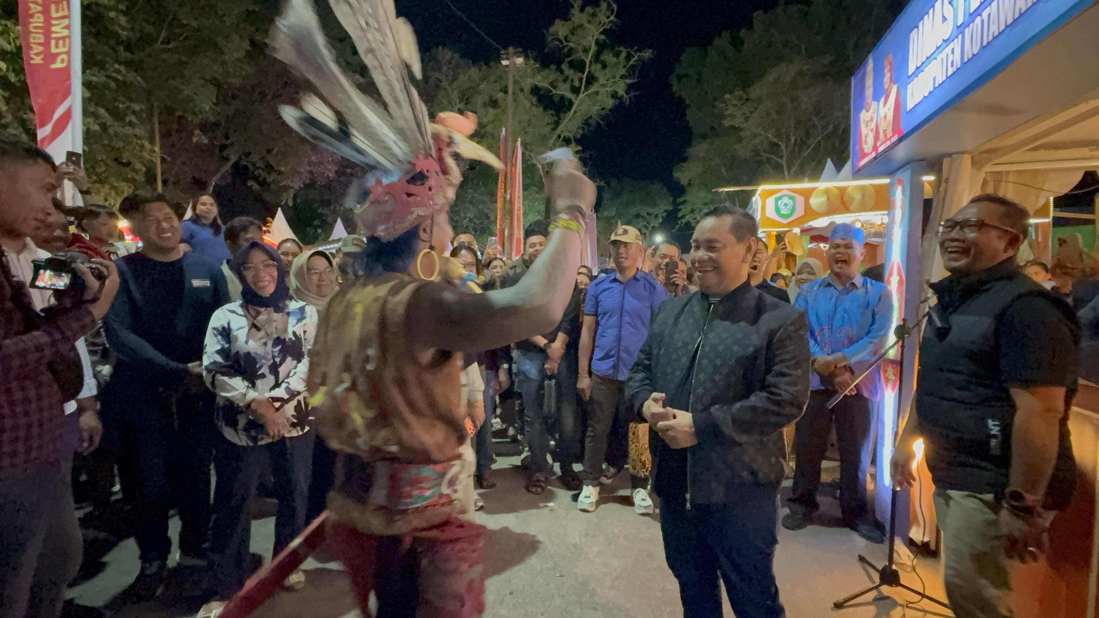 Bupati Kotim Halikinnor saat berinteraksi dengan seniman berpakaian Adat Dayak di arena Sampit Expo 2026, Jumat (9/1) malam.