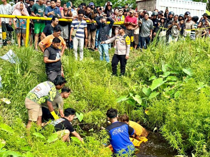 EVAKUASI : Tim Kepolisian bersam masyarakat saat melakukan evakuasi jenazah Abdi Saputra (25) yang ditemukan mengambang di rawa-rawa Jalan G Obos Ujung, Kota Palangka Raya pada Jumat (9/1/2026).