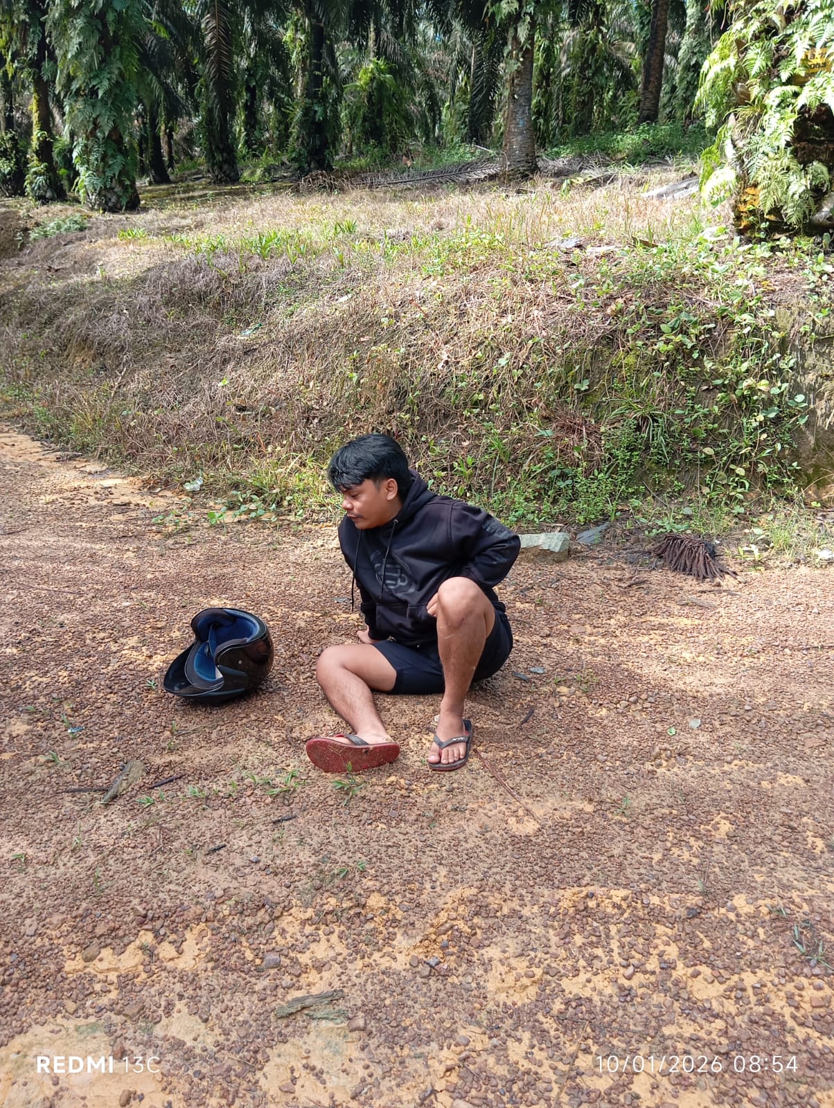 PERAMPOKAN: Panji Trisno (25) syok terduduk di lokasi kejadian usai dirampok, Sabtu (10/1/2026) pagi sekira pukul 08.45 WIB. FOTO IST/RADAR SAMPIT