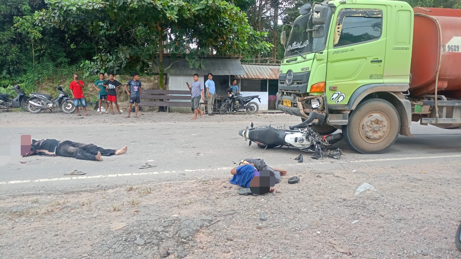TERKAPAR: Dua pengendara motor terkapar usai menabrak truk CPO. (warga/radar sampit)