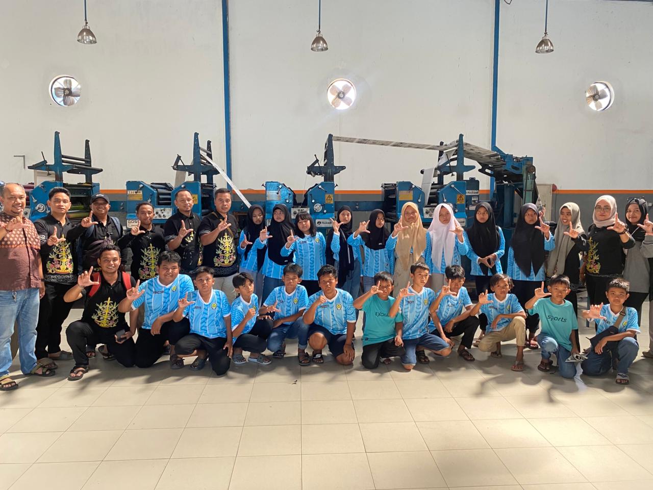 TAMBAH WAWASAN: Kepala SDS Tunas Agro Nur Ali, para guru pendamping dan murid berfoto bersama di gedung percetakan Radar Sampit saat melaksanakan kunjungan edukasi, Minggu siang(25/1).ALFIAN/RADAR