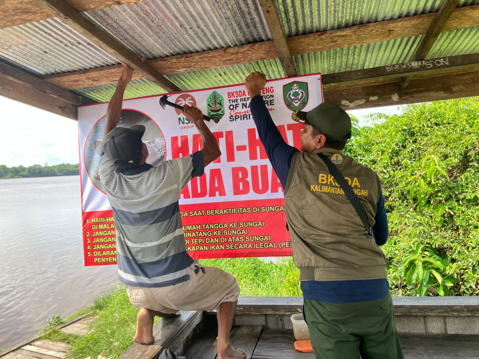 Petugas BKSDA Resort Sampit memasang spanduk di sejumlah titik di kawasan tepi Sungai Mentaya dibantu warga. (BKSDA Resort Sampit)