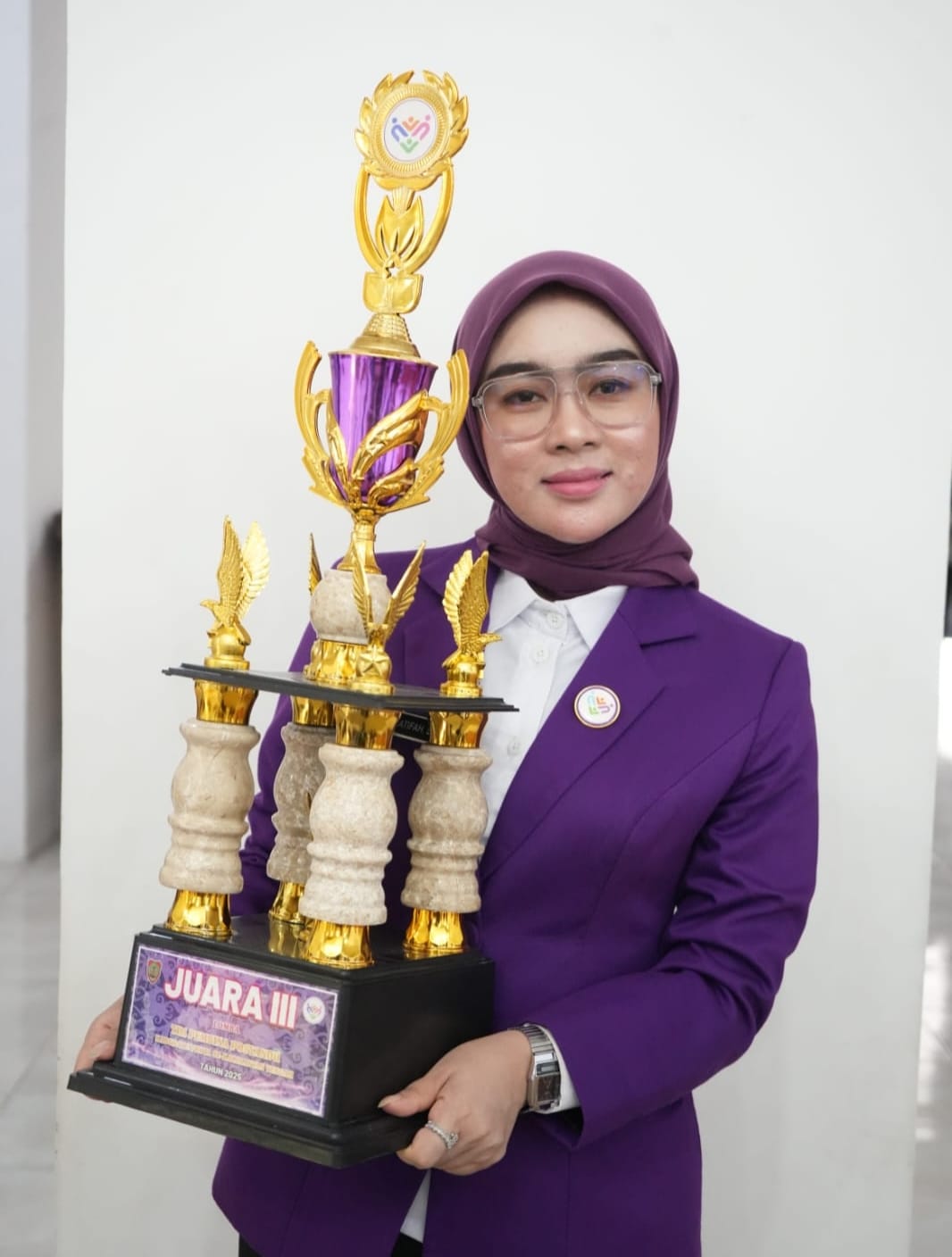 Ketua Tim Pembina Posyandu Kabupaten Lamandau Norol Latifah Rizky Aditya Putra saat menerima piala juara III di Palangkaraya