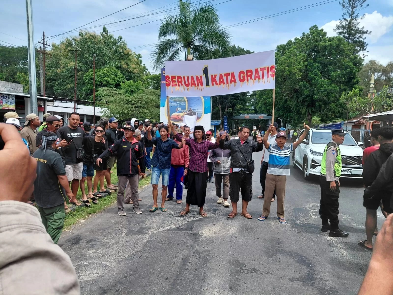 UNJUK RASA: Warga tiga desa memampang spanduk berisi tuntutan di Bendungan Lahor, Desa Karangkates, Kecamatan Sumberpucung, Senin (26/1/2026). (Radar Malang)