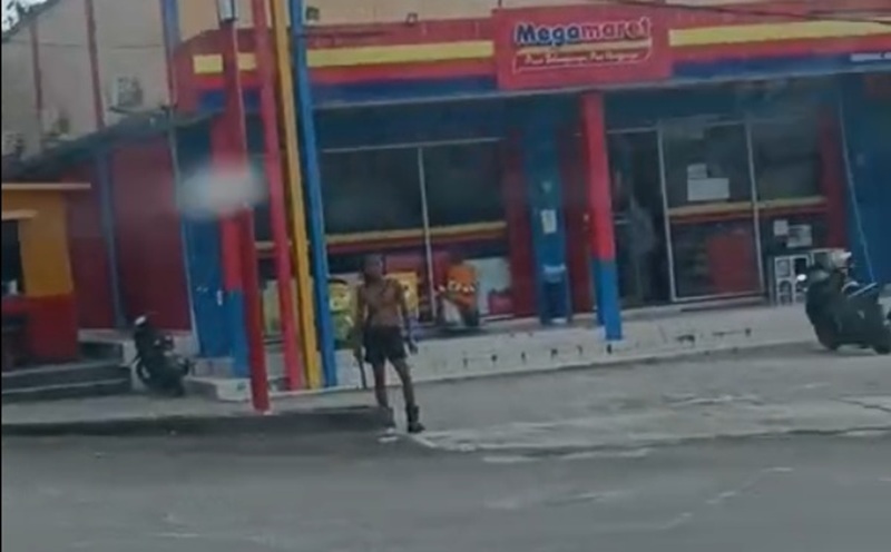 BIKIN RESAH: ODGJ membuat resah warga dengan aksinya menakut-nakuti pengguna jalan sambil membawa benda tajam di sekitar traffic light Jalan Samari, Pangkalan Bun. (Warga/Radar Pangkalan Bun)