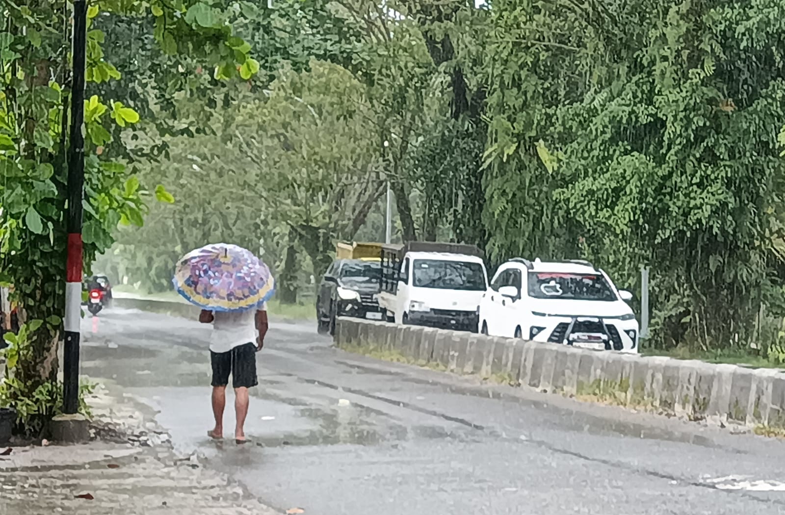 Suasana salah jalan di Kota Sampit, Kabupaten Kotawaringin Timur, saat dilanda hujan. Tampak pejalan kaki menggunakan payung di tengah hujan. (Oes/Radar Sampit)