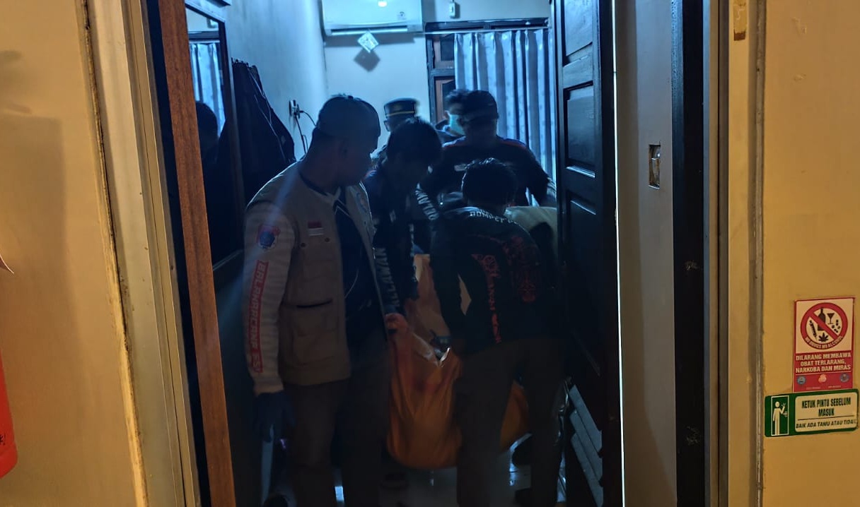 EVAKUASI: Aparat kepolisian dan petugas medis serta relawan saat mengevakuai jenazah dari salah satu kamar mess (penginapan) di Jalan MT Haryono Sampit. (Polres Kotim/Radar Sampit)