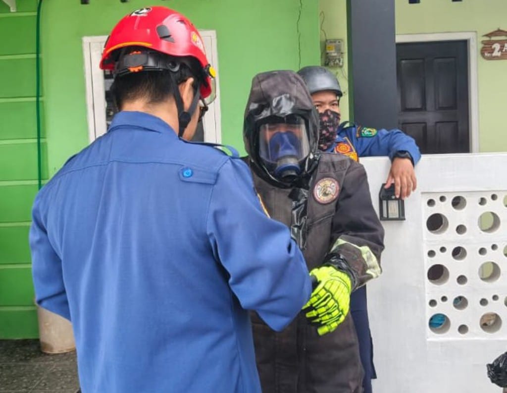 Petugas Disdamkarmat Kotim menggunakan pakaian pengaman sebelum mengevakuasi sarang mau lebah yang bersarang di atas pohon mangga di depan rumah warga di Jalan Taman Siswa, Baamang, Minggu (8/2/2026).