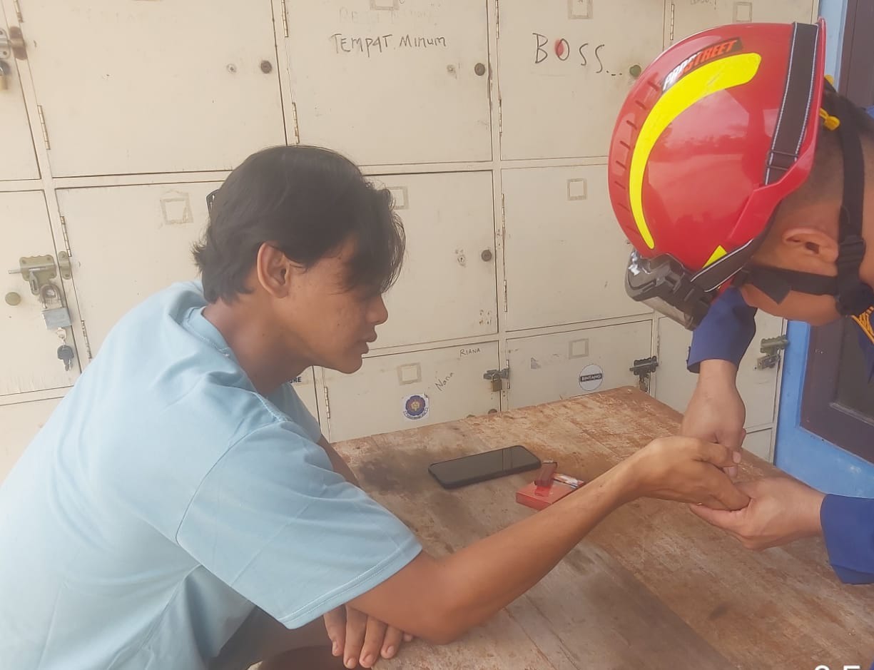 Petugas Disdamkarmat Kotim saat berupaya melepas cincin yang menjepit tangan seorang pria. (Disdamkarmat Kotim)